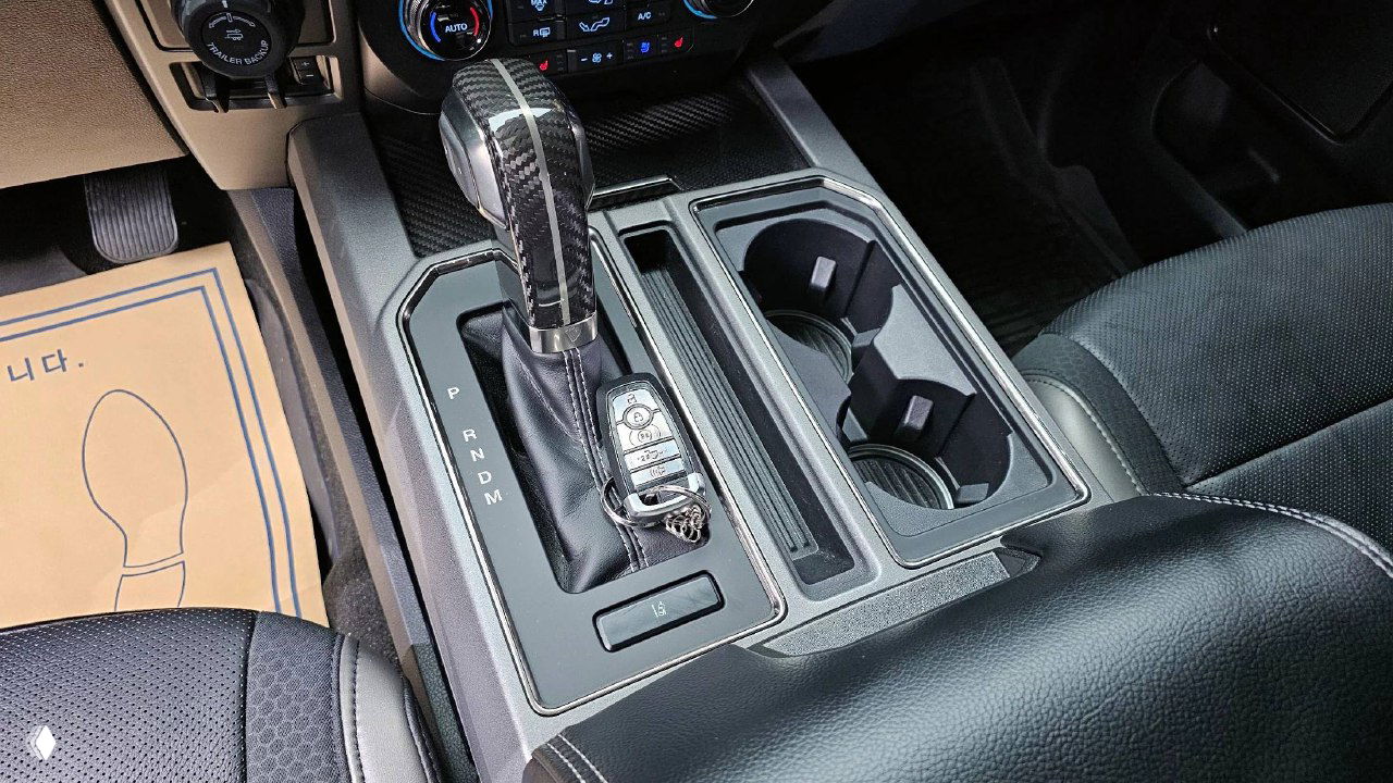 Селектор АКПП, подстаканники и ключ на центральном тоннеле Ford F-150 Raptor 2020 — вид внутренней отделки и рукояти коробки передач