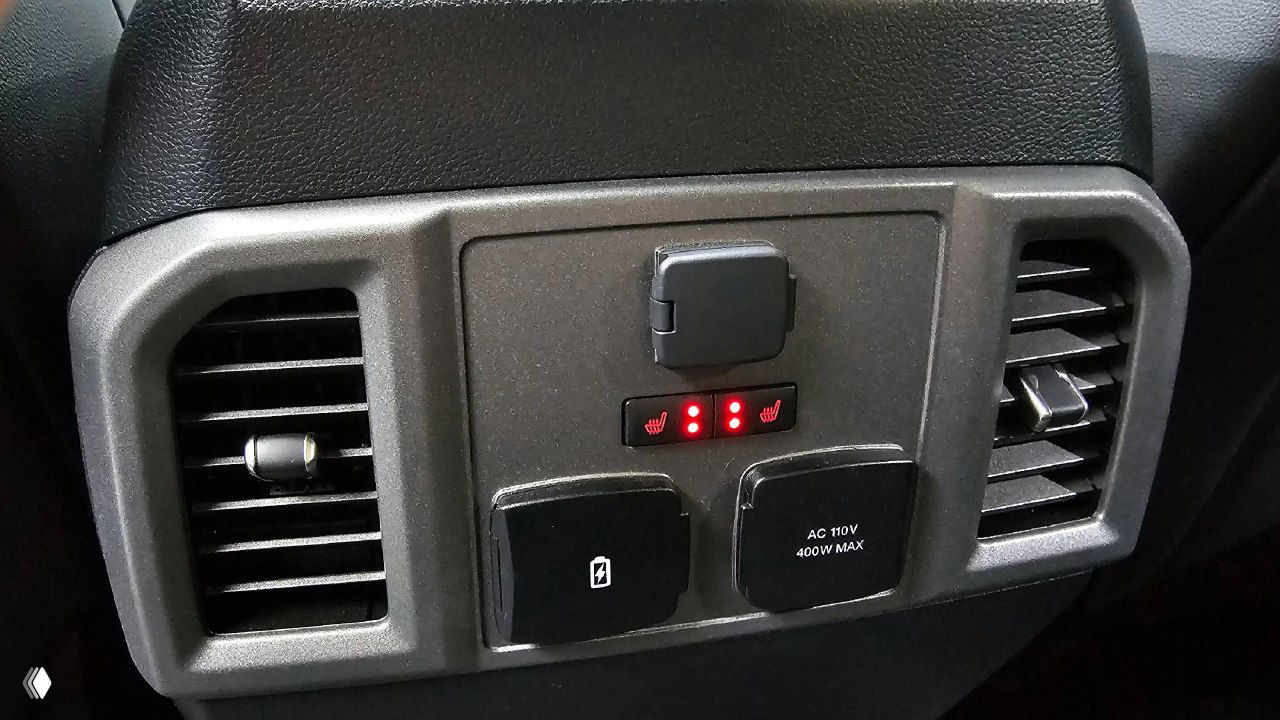 Панель с розетками и индикаторами подогрева на задней части центрального туннеля Ford F-150 Raptor, крупный план розеток и вентиляционных решёток