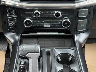 Фрагмент центральной консоли Ford F-150 Raptor: рычаг АКПП, подстаканники и элементы управления климатом, аккуратная отделка деталей.