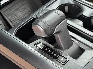 Крупный план рычага переключения передач и маркировки режимов АКПП в салоне Ford F-150 Raptor, видно отделку ручки и посадочные ниши.