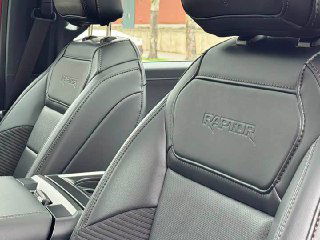 Крупный план передних подголовников с тиснением Raptor на кожаной обивке сидений Ford F-150, видна фактура и качество швов.