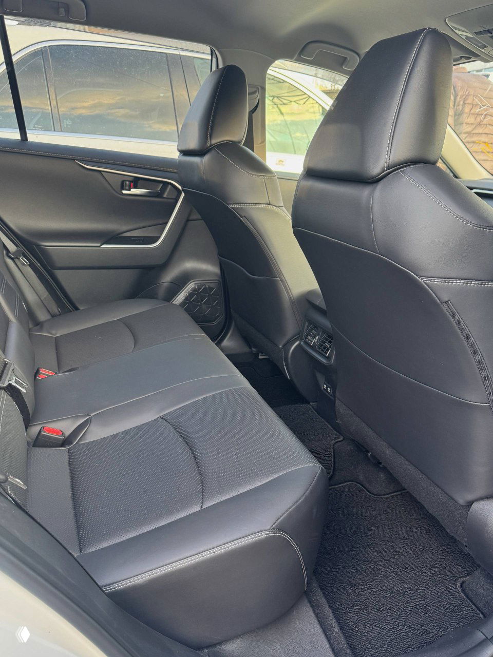 Задние сиденья Toyota RAV4: вид на пространство для ног и обивку, кресла в хорошем состоянии, на фото видно расположение вентиляционных дефлекторов и подголовников.