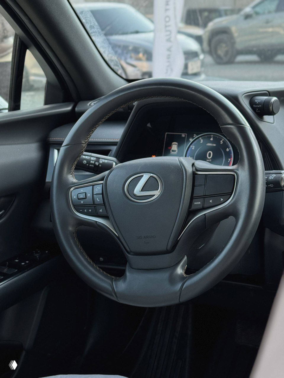 Рулевое колесо Lexus с логотипом L; вид на комбинацию приборов и часть торпеды, состояние рулевой колонки и кнопок управления.