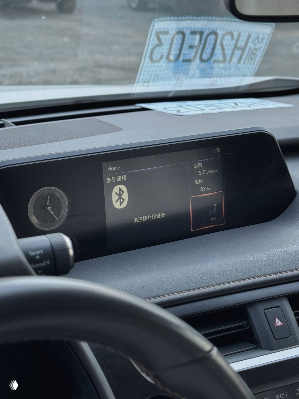 Ближний план центрального дисплея и блока управления мультимедиа Lexus UX200; на экране отображается меню на китайском языке.