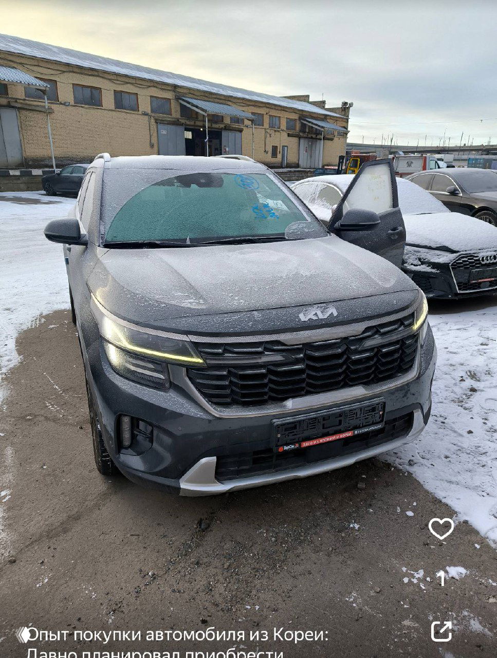 Фотография Kia Seltos на парковке после доставки: передняя часть машины покрыта инеем, открыта дверь, видна общая геометрия авто.