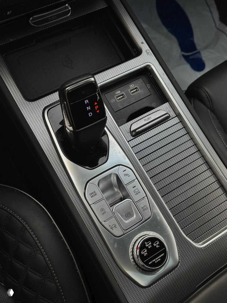 Селектор автоматической коробки передач и центральный тоннель SsangYong NEW Rexton: кнопки режимов, порты USB и отделение для мелочей.