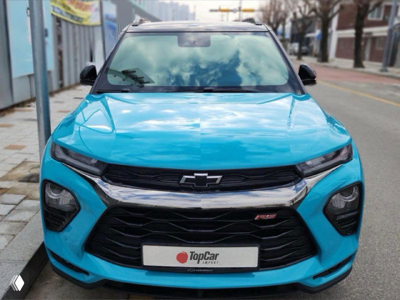 Синий Chevrolet Trailblazer крупным планом спереди: агрессивная передняя оптика, эмблема Chevrolet и логотип TopCar на номере.