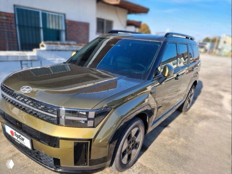 Вид в три четверти на тёмно-зелёный кроссовер на открытом воздухе; фотография показывает кузов, колёсные диски и общий внешний вид.