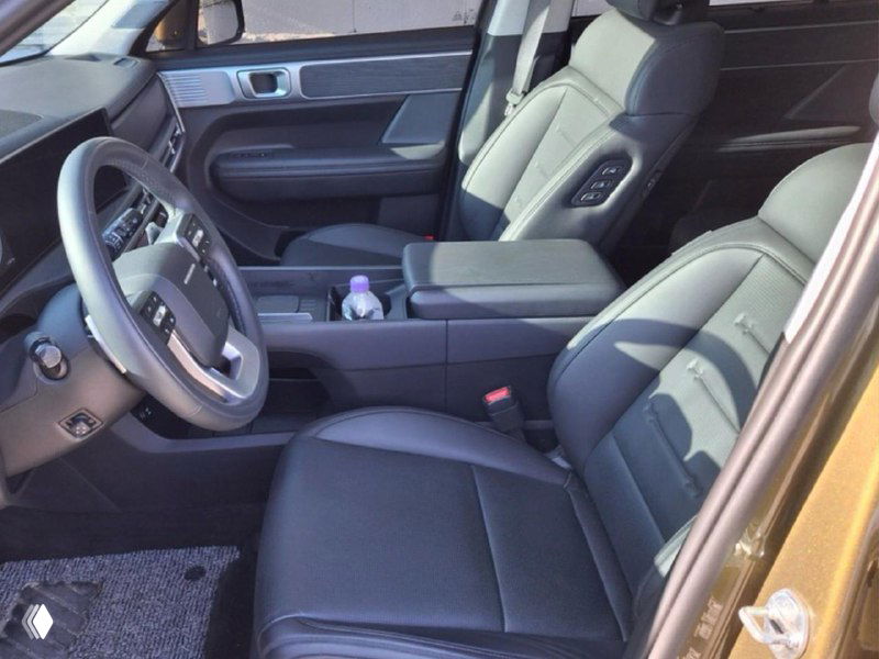 Фото передней части салона кроссовера: пассажирское кресло, центральный подлокотник и панели управления — состояние и отделка.