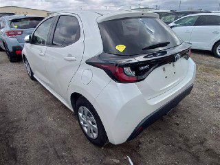 Toyota Yaris 2021 белого цвета — вид сзади на автоярде; видна задняя оптика, багажник и элементы заднего бампера на парковке.