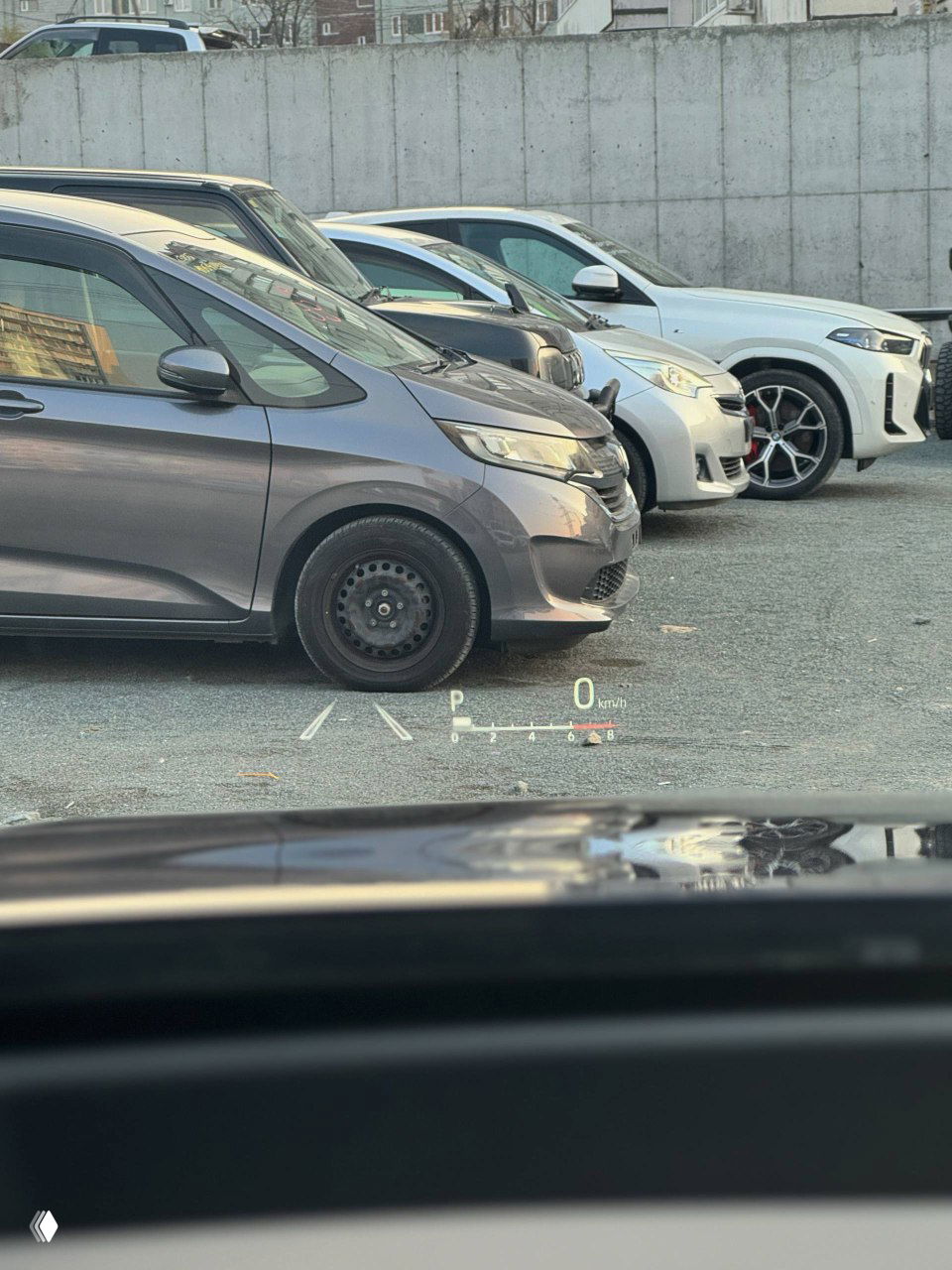 Вид через лобовое стекло на парковку и другие автомобили, отображение проекции HUD на лобовом стекле Toyota Highlander 2025 в режиме парковки