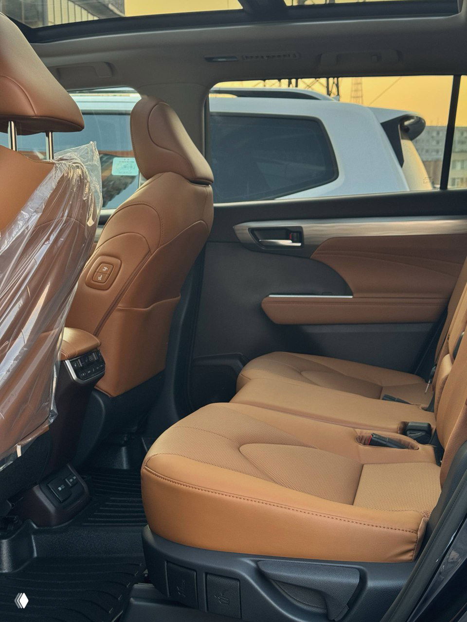 Вид заднего ряда сидений Toyota Highlander 2025: просторный салон, коричневые кожаные сиденья и подголовники, кресла без видимых следов эксплуатации
