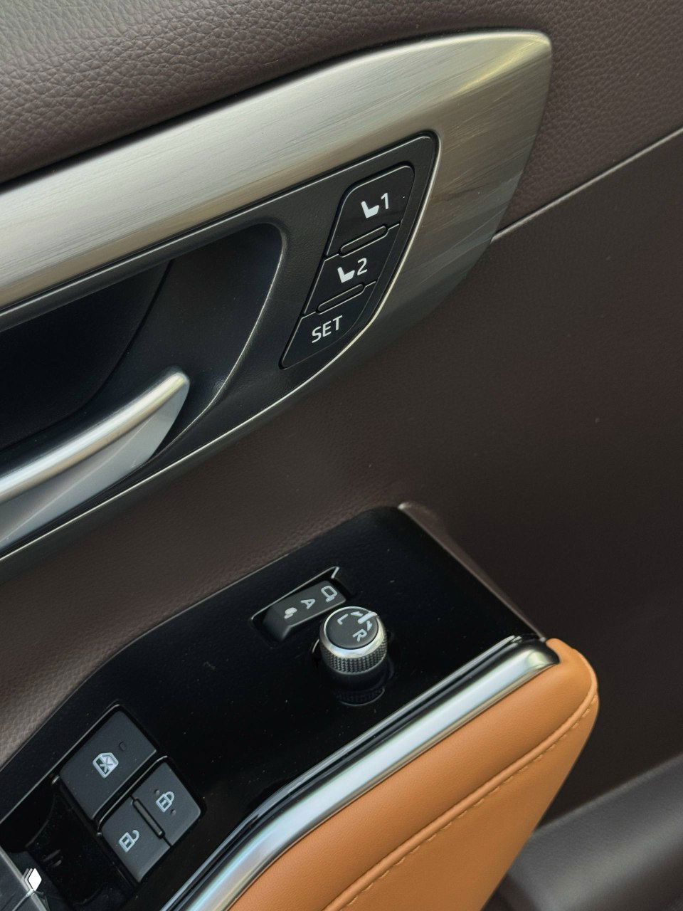 Кнопки памяти сиденья и элементы управления электроприводом зеркал на водительской двери Toyota Highlander 2025 с отделкой из коричневой кожи и пластика