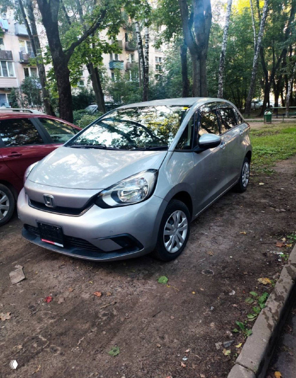 Ночное фото серого Honda Freed на стоянке; вид спереди, заметны капот, решётка и лобовое стекло в свете фар.