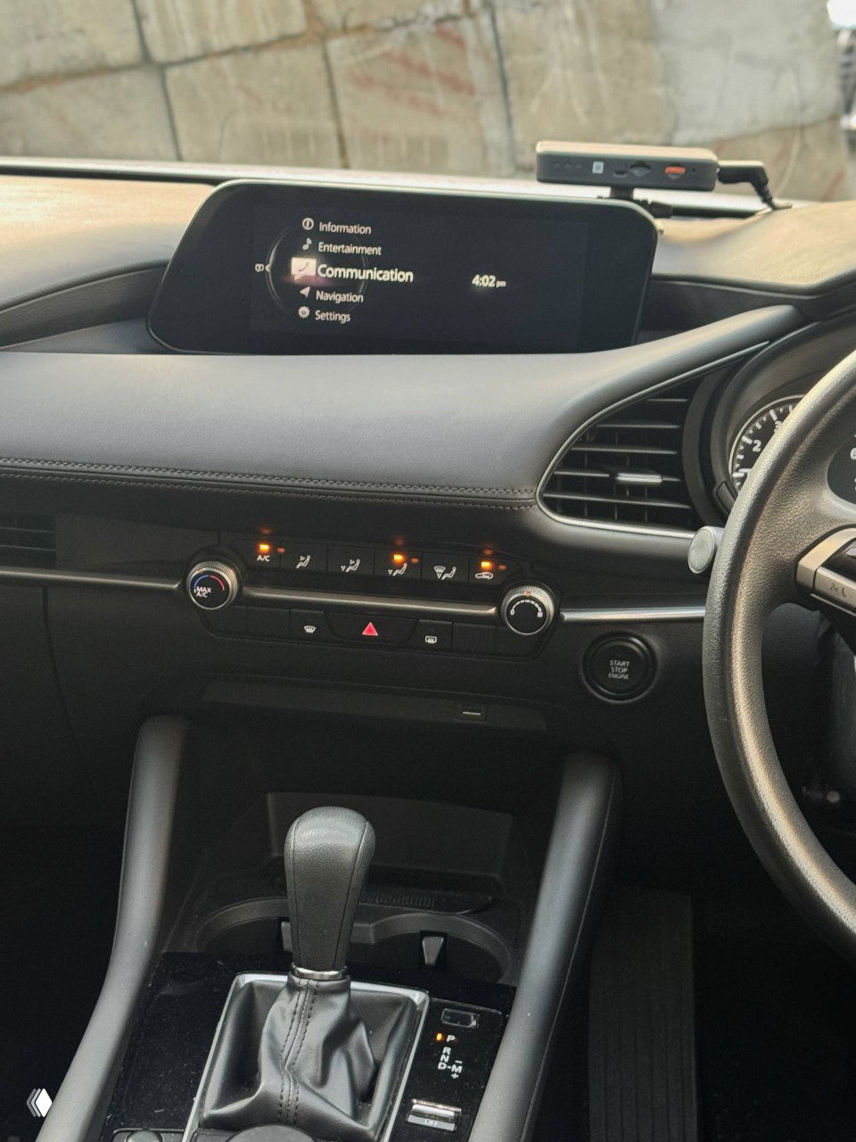 Центральная консоль и панель управления климата Mazda 3 2020: экран, кнопки, регуляторы и общее состояние передней части салона.