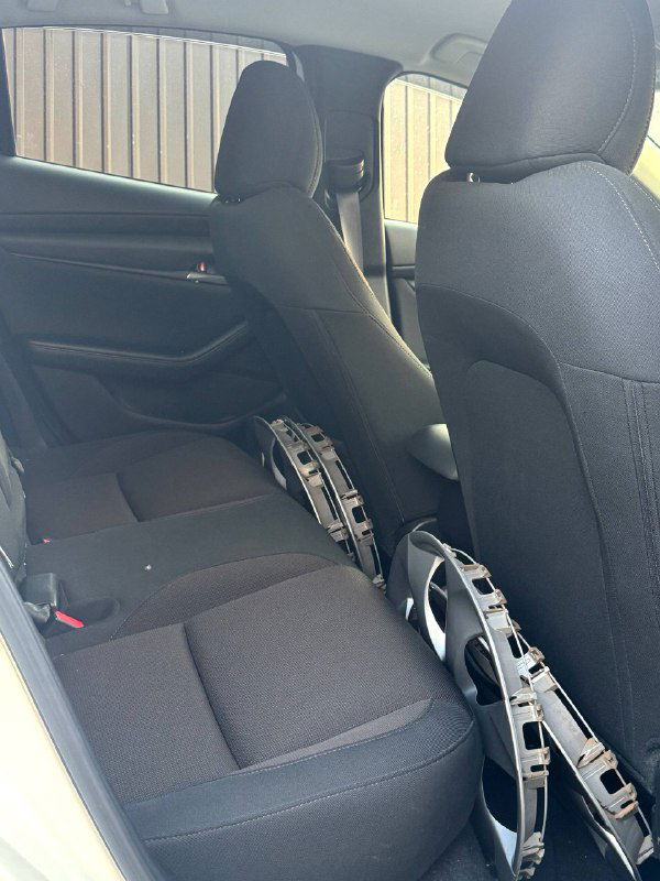 Задний ряд сидений Mazda 3 2020: тканевая обивка, посадочные места и на полу размещены колпаковые накладки — общий вид второго ряда салона.