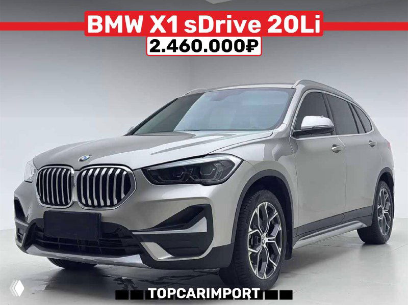 Фото серебристого BMW X1 sDrive 20Li в автосалоне; крупный план передней части и колес, подпись с ценой 2.460.000₽ над машиной.