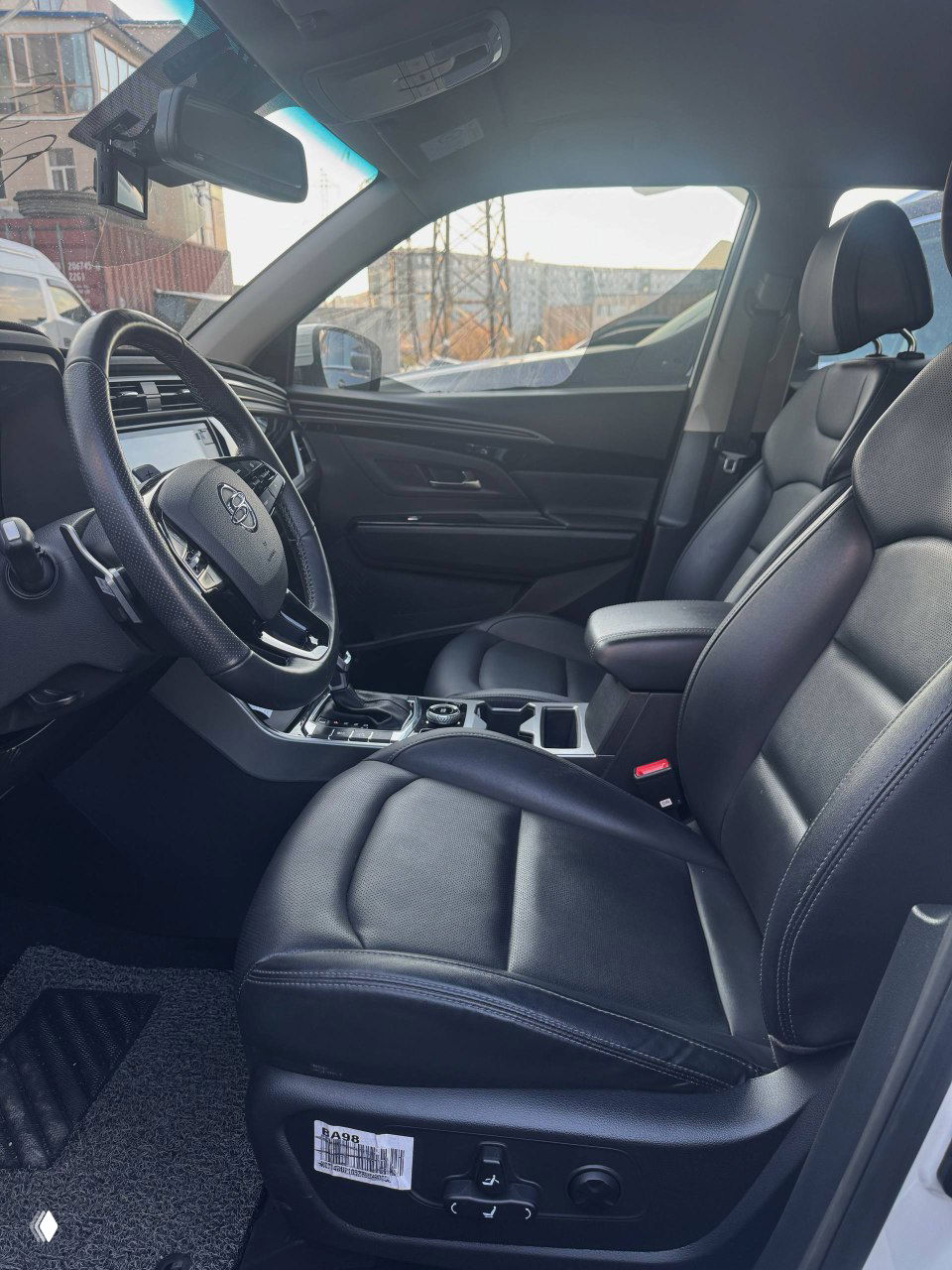 Передние кожаные сиденья и интерьер SsangYong Korando: крупный план пассажирского и водительского места, центр салона и подлокотник.