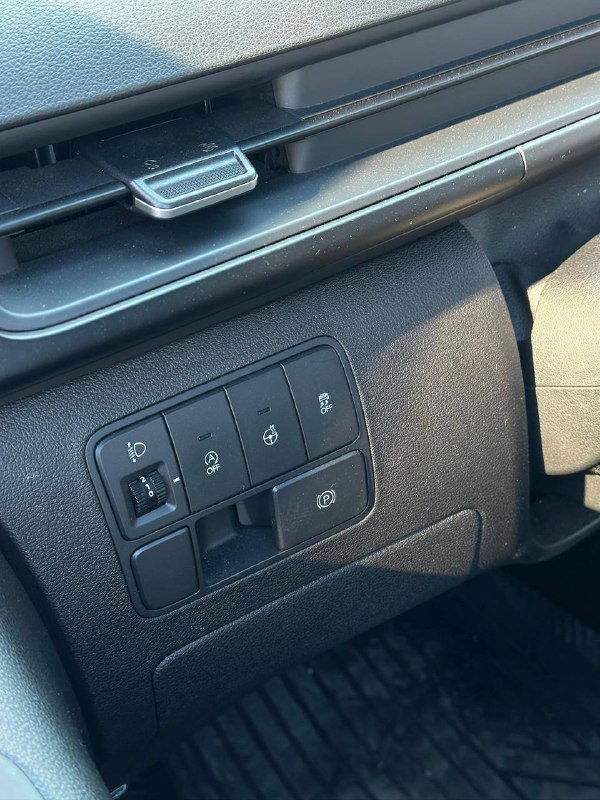 Панель управления слева от руля Hyundai Staria: кнопки функций автомобиля (освещение, ассистенты, прочие переключатели) в салоне крупным планом.