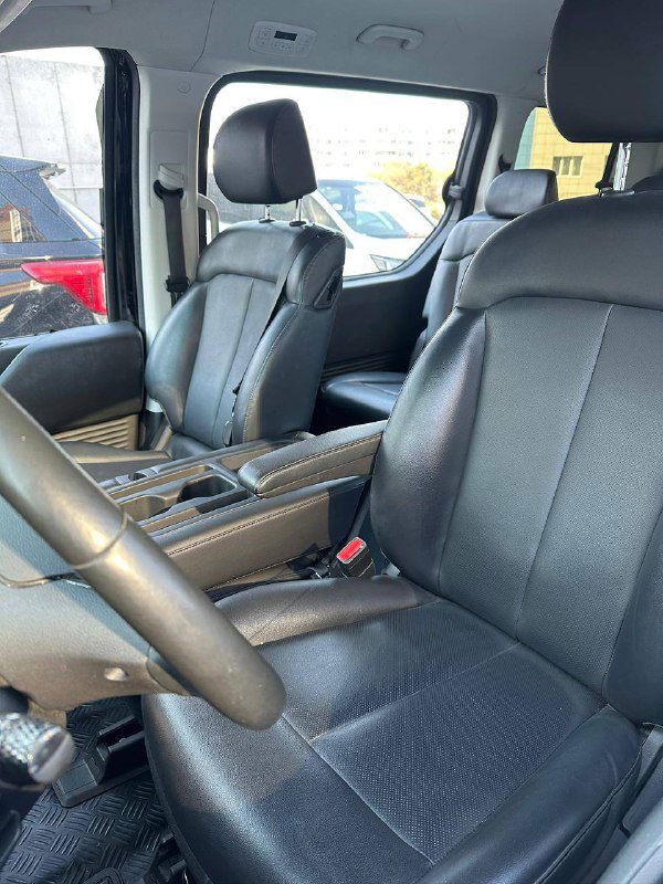 Передние кожаные кресла Hyundai Staria: вид с водительской стороны, центральная консоль между сиденьями, состояние обивки и ремней безопасности.