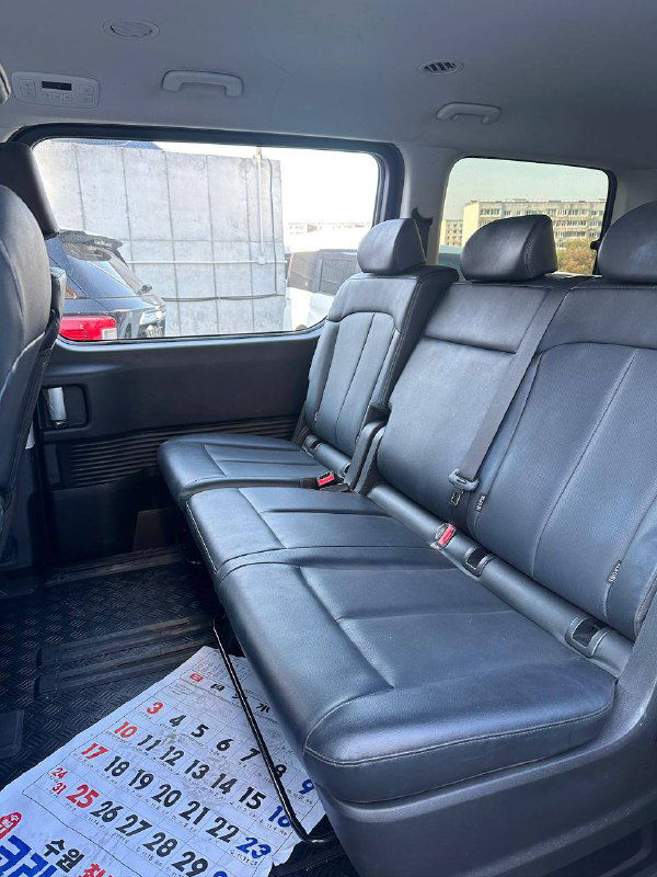 Задний трёхместный кожаный диван Hyundai Staria: вид со стороны дверного проёма, посадочные места и пространство для пассажиров на втором ряду.