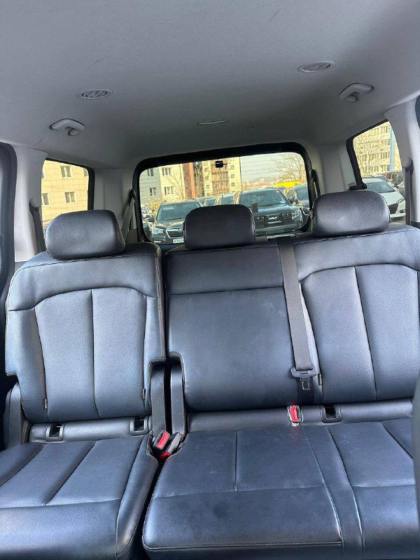 Вид на посадочные места и подголовники Hyundai Staria с тыльной стороны салона: общий обзор третьего ряда и окон автомобиля.