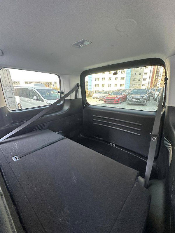 Багажное отделение Hyundai Staria со сложенными сиденьями: вид на грузовую зону, заднее окно и место для перевозки крупного груза в минивэне.