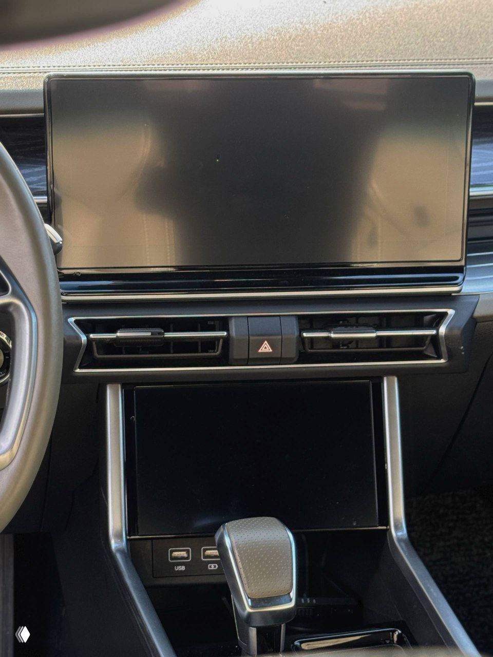 Центральная консоль и крупный сенсорный дисплей SsangYong Torres: два уровня экрана, воздуховоды, кнопка аварийной сигнализации и глянцевая панель.