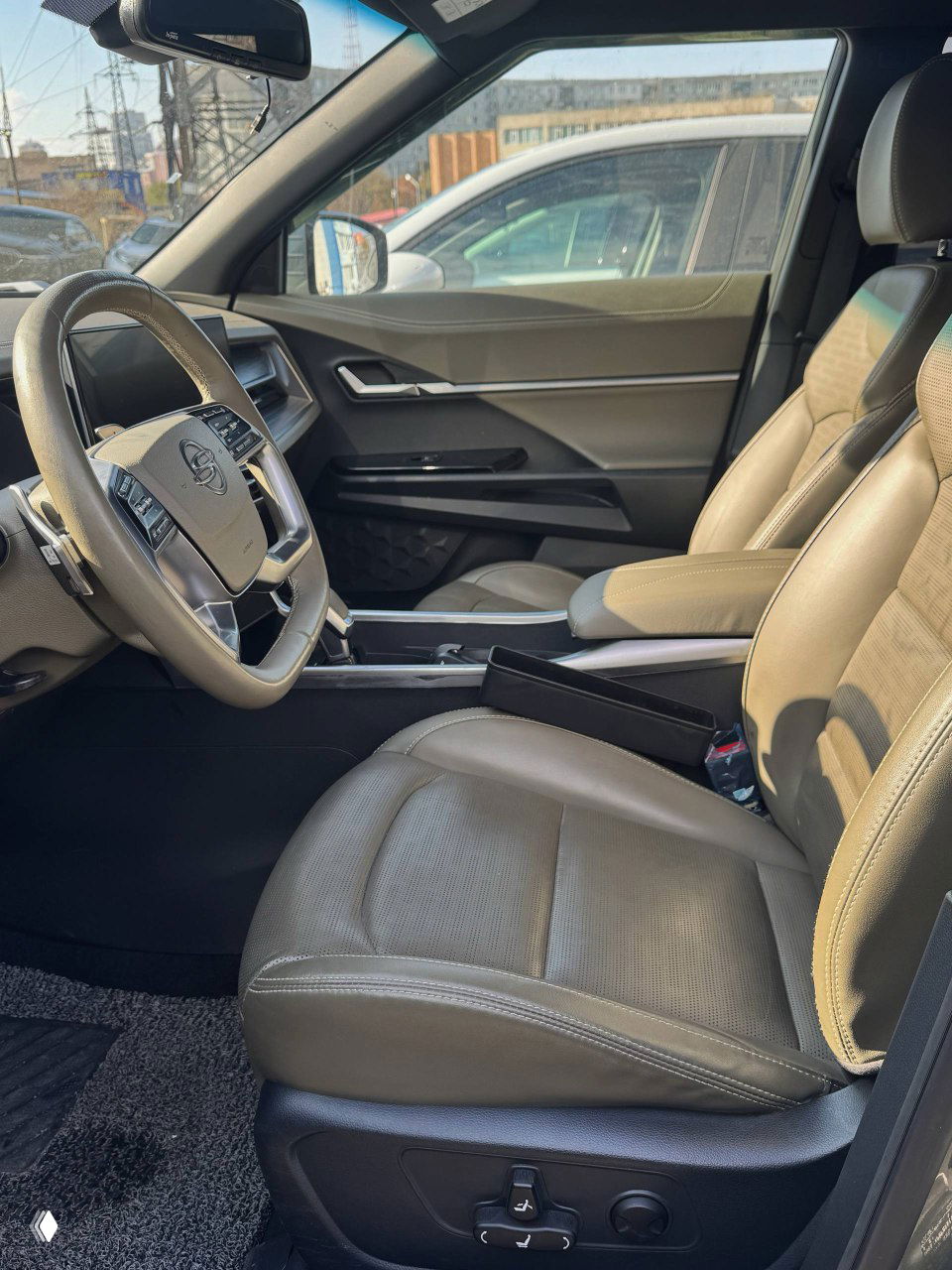 Передние сиденья SsangYong Torres: комбинированная кожаная/тканевая обивка, подлокотник, регуляторы положения и общий вид водительского места.