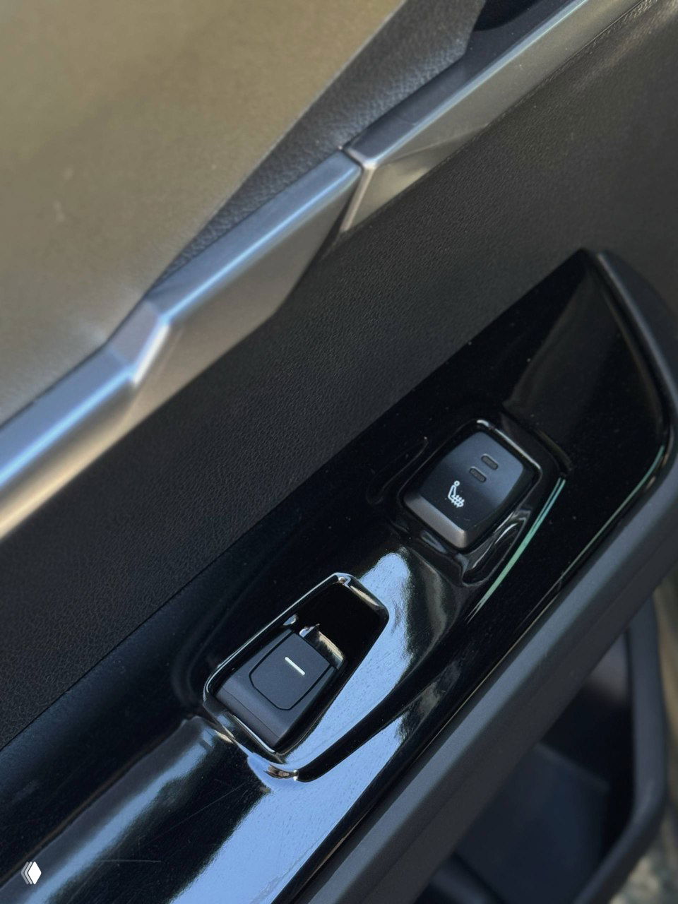 Крупный план панели двери SsangYong Torres: кнопки стеклоподъёмников, переключатель подогрева сиденья и глянцевая окантовка вокруг элементов управления.