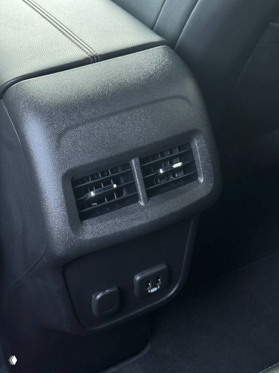 Задняя часть центрального туннеля Chevrolet Equinox с воздуховодами для задних пассажиров и розетками USB/12В, крупный план удобств для пассажиров и состояния отделки.