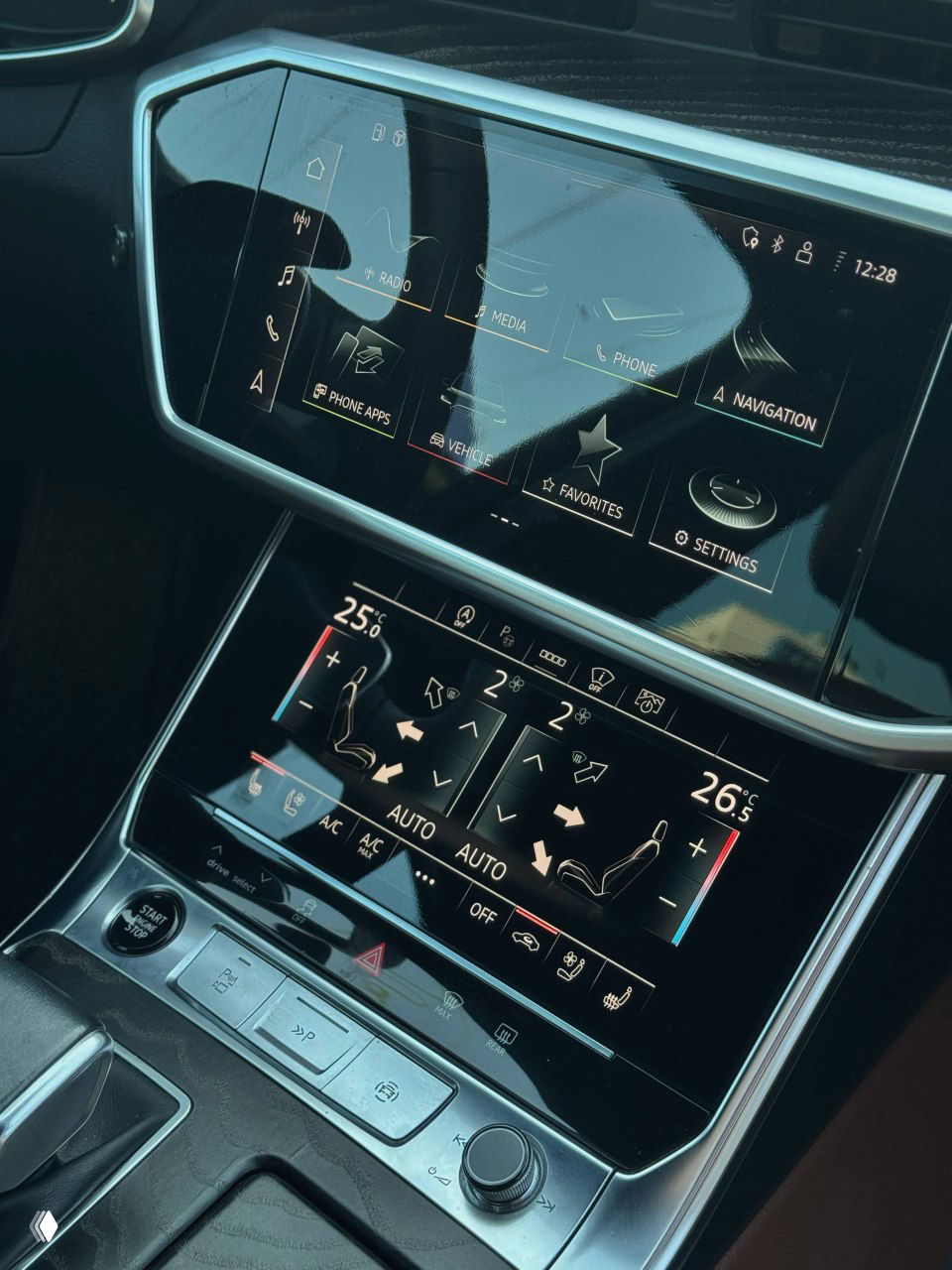 Крупный план центральной панели с сенсорными дисплеями и климат-контролем Audi A6; демонстрация мультимедиа и настроек климата в салоне автомобиля.