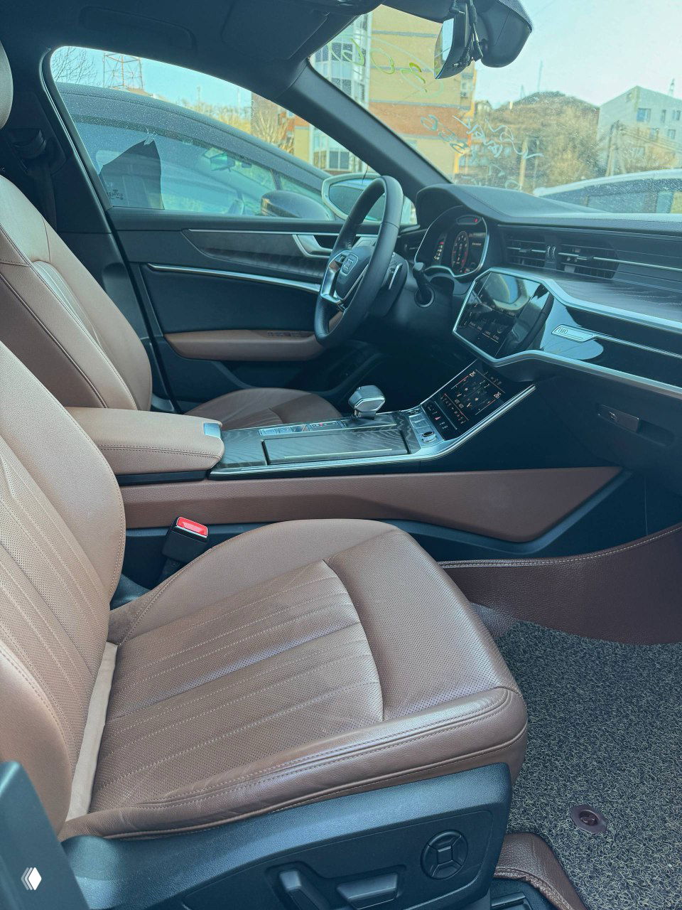 Детальное фото передней части центрального тоннеля и вокруг селектора передач Audi A6, коричневые кожаные элементы и контрастная отделка видны крупно.