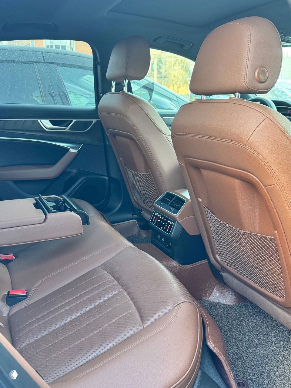 Пассажирское место и общий вид передней части салона Audi A6 с коричневой кожей и отделкой; фото демонстрирует состояние сидений и панелей.