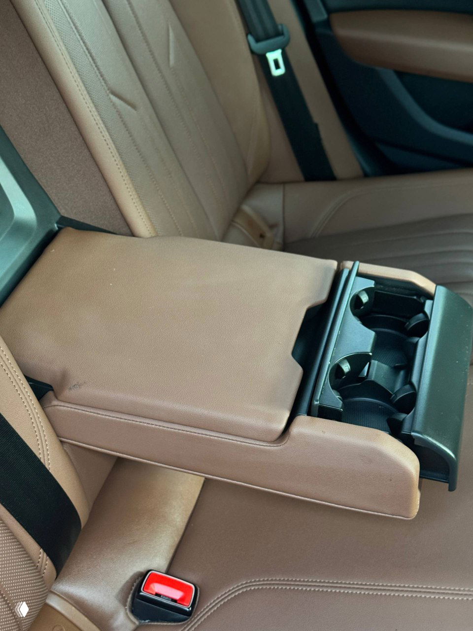 Задние сиденья Audi A6, видно место для ног, подлокотник с подстаканниками и общий простор заднего ряда — состояние салона для пассажиров.