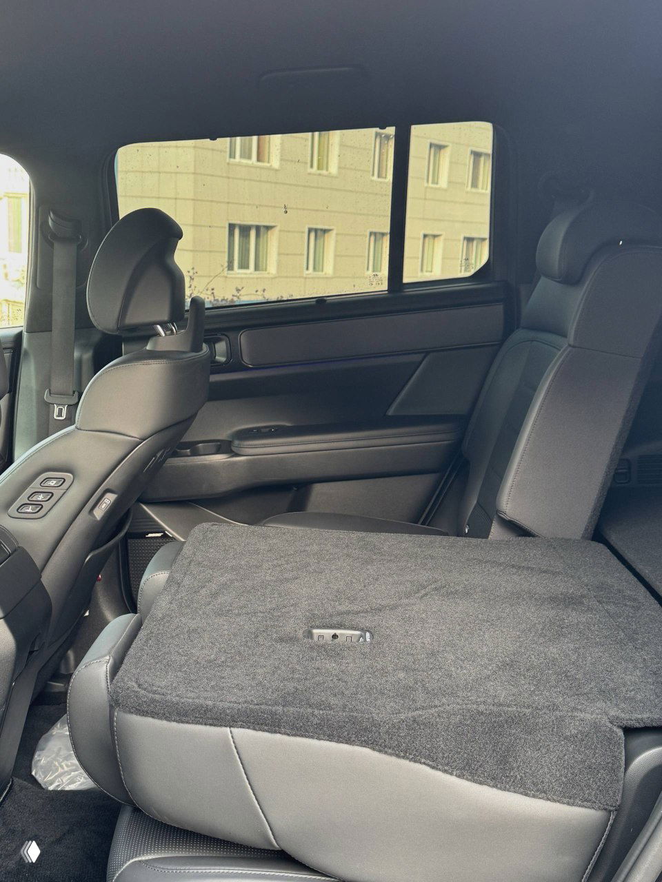 Крупный план управляющей панели двери Hyundai Santa Fe: кнопка подогрева/стеклоподъёмника и детальная отделка поручня