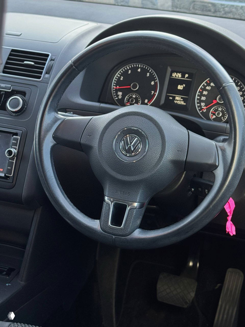 Крупный план рулевого колеса Volkswagen с эмблемой VW, приборная панель с тахометром и спидометром, показан пробег около 44 000 км.