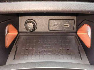 Отсек с беспроводной зарядкой и портами USB в Ford Ranger: вид панели с розеткой, USB‑разъёмами и местом для мелких предметов в центральной консоли.