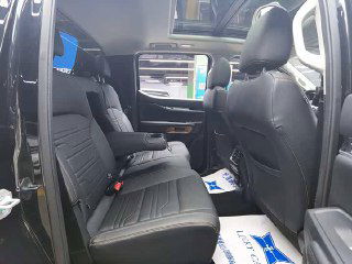 Задний ряд сидений Ford Ranger: чёрные кожаные/тканевые сиденья, пространство для пассажиров и общий вид салона с открытой дверью в салоне шоурума.