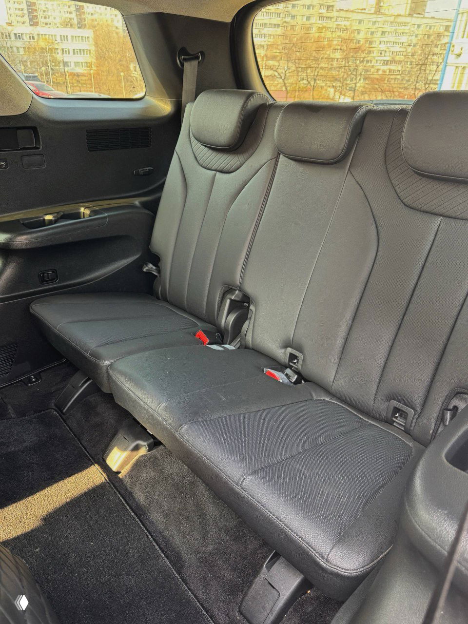 Панель управления климатом и обогревом для задних пассажиров Hyundai Palisade — кнопки, дисплей и розетка 12В, крупный план на консоль сзади.