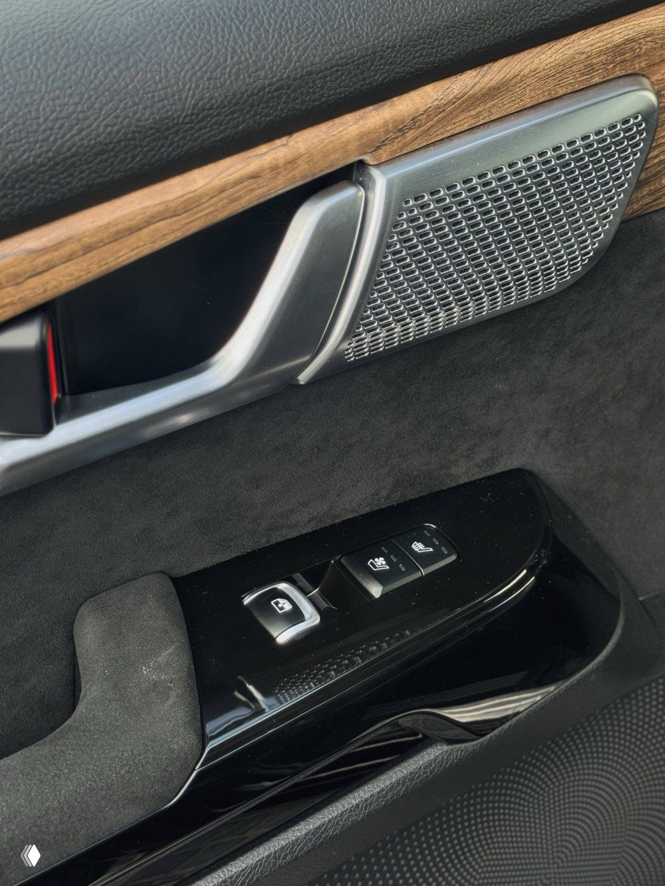 Крупный план дверной панели и блока управления стеклоподъёмниками KIA Mohave: декоративная вставка под дерево и элементы управления сиденьем.