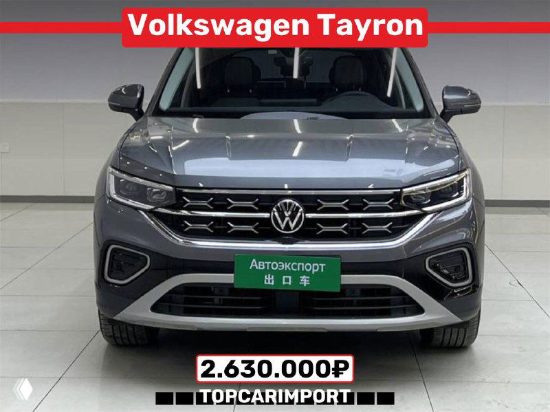Фронтальный вид Volkswagen Tayron серого цвета внутри автосалона в Китае, видна приборная панель и табличка с ценой 2.630.000₽
