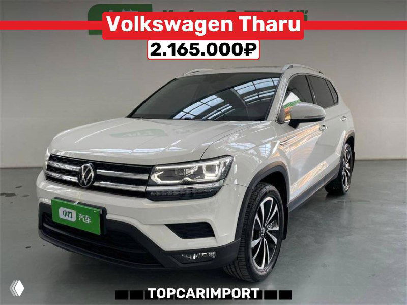 Фронтально-боковой вид Volkswagen Tharu в светлом цвете в выставочном зале, видны колёса и цена 2.165.000₽, подпись TOPCARIMPORT