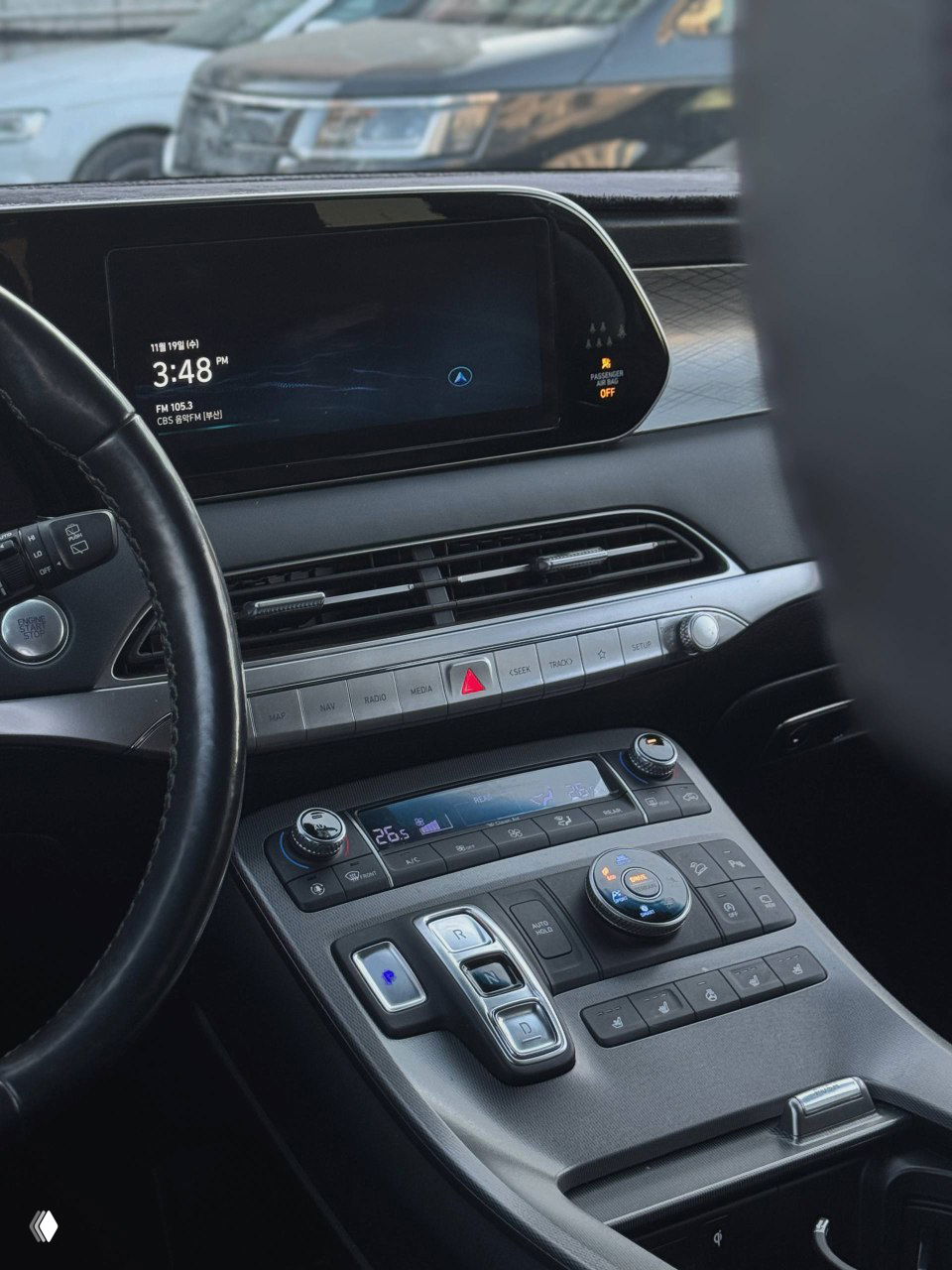 Панель приборов и медиасистема Hyundai Palisade, крупный дисплей по центру торпеды и консоль с климат-контролем и селектором режимов работы трансмиссии.