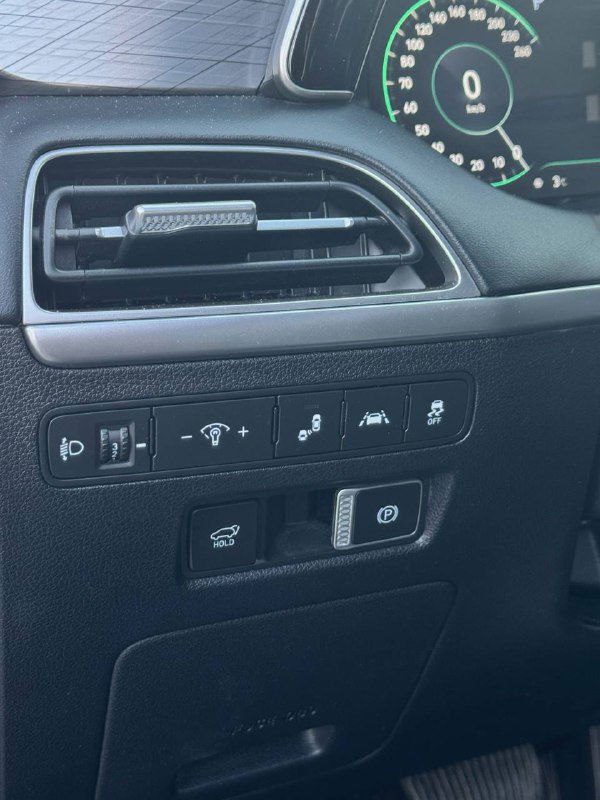 Крупный план блока управления около водительской двери: кнопки подогрева, ассистенты и регуляторы подсветки, детали отделки и вентиляции в салоне Hyundai.