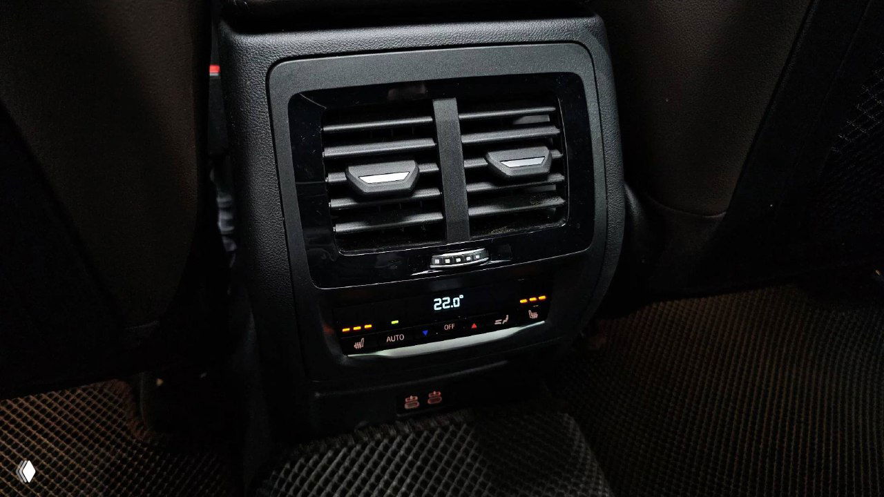 Зона климат-контроля для задних пассажиров BMW X4 — вентиляционные дефлекторы и цифровой индикатор температуры 22.0°, видны элементы управления.