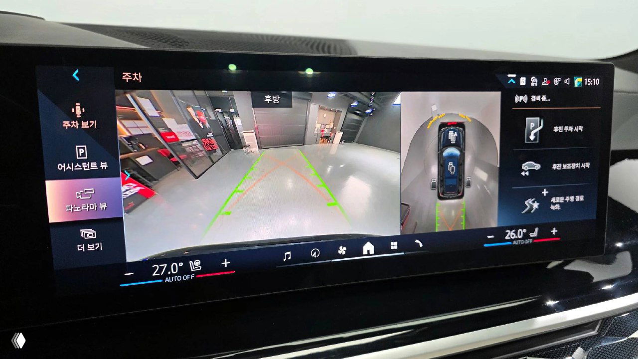 Широкоформатный дисплей парковочной камеры BMW X7 с обзором вокруг автомобиля и визуализацией траекторий парковки на экране мультимедиа.