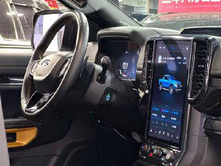 Крупный план приборной панели и вертикального мультимедийного дисплея Ford Ranger с интерфейсом автомобиля, элементы управления на руле видны.