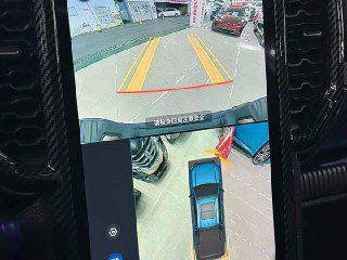 Камера заднего вида и обзор вокруг автомобиля на экране центрального дисплея Ford Ranger, дорожная разметка и парковочное пространство видны.