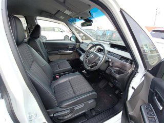 Передние сиденья Honda Freed 2018: тканевая обивка, подлокотник, рулевая колонка и центральная консоль в рабочем состоянии, вид с открытой двери.